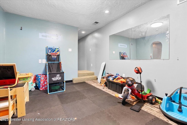 playroom with rubber floors and a textured ceiling
