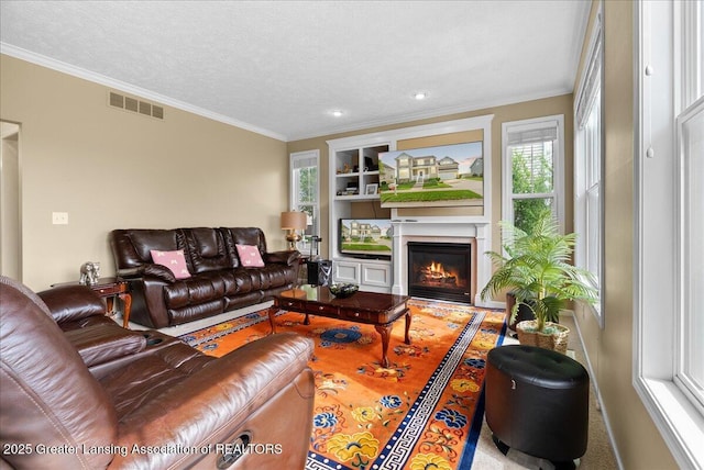 3837 Plover Pl, East Lansing, MI 48823 - living area featuring crown molding, a glass covered fireplace, built in shelves, a textured ceiling, and recessed lighting
