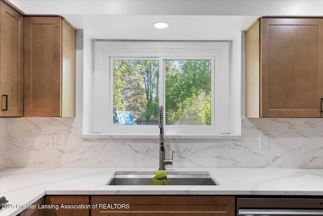 1263 Leeward Dr, Okemos, MI 48864 - kitchen with a sink, dishwashing machine, light stone countertops, and backsplash