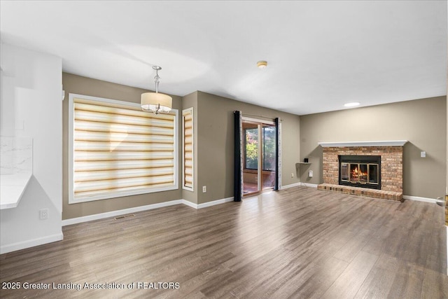 1263 Leeward Dr, Okemos, MI 48864 - unfurnished living room featuring wood finished floors, a fireplace, and baseboards