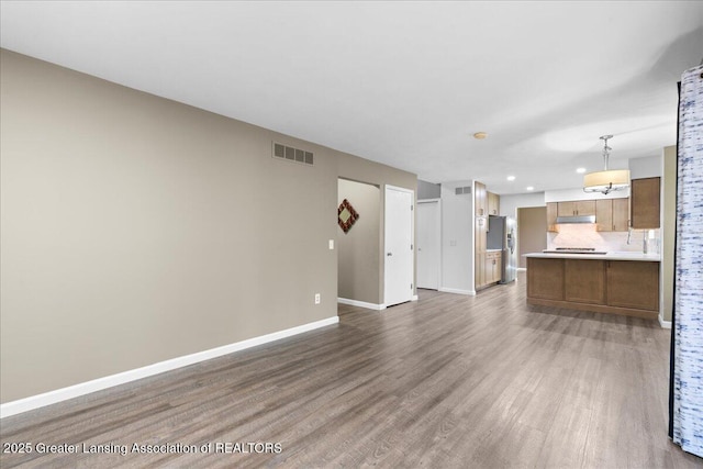 1263 Leeward Dr, Okemos, MI 48864 - unfurnished living room with wood finished floors, baseboards, and recessed lighting