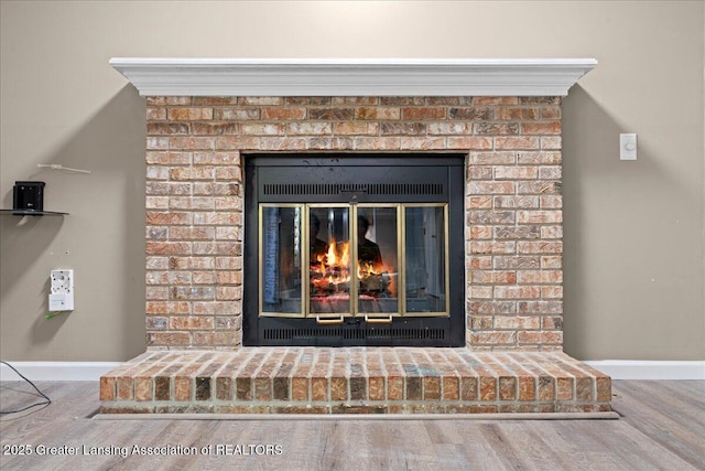 1263 Leeward Dr, Okemos, MI 48864 - detailed view of a brick fireplace, wood finished floors, and baseboards