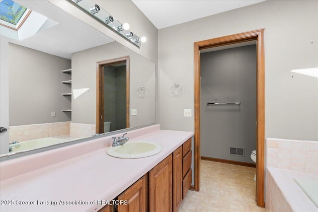 1263 Leeward Dr, Okemos, MI 48864 - full bath with a skylight, toilet, vanity, and a bath
