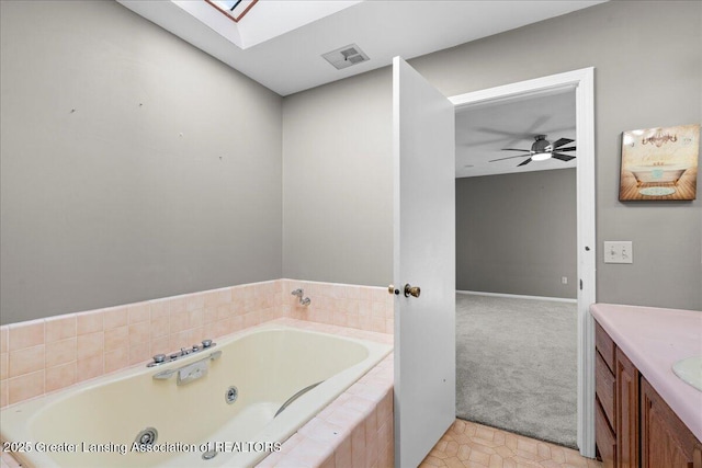 1263 Leeward Dr, Okemos, MI 48864 - full bath featuring a skylight, a jetted tub, ceiling fan, vanity, and baseboards