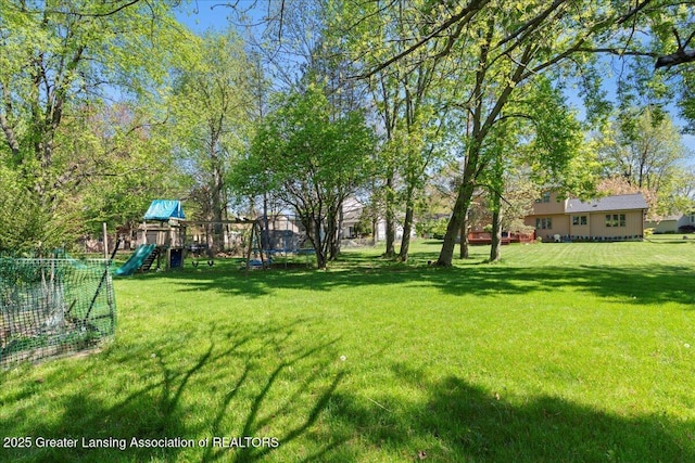 1263 Leeward Dr, Okemos, MI 48864 - view of green lawn with a trampoline and a playground