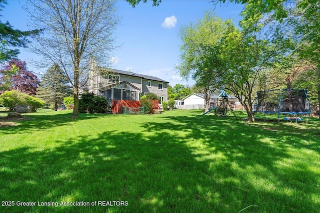 1263 Leeward Dr, Okemos, MI 48864 - view of grassy yard with a trampoline and a playground