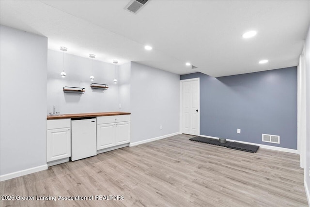 1263 Leeward Dr, Okemos, MI 48864 - kitchen with light wood-type flooring, white cabinetry, baseboards, and recessed lighting