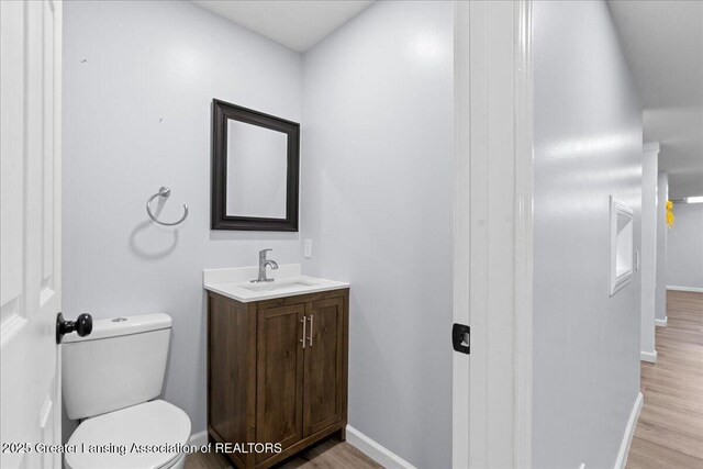 1263 Leeward Dr, Okemos, MI 48864 - bathroom with wood finished floors, baseboards, vanity, and toilet