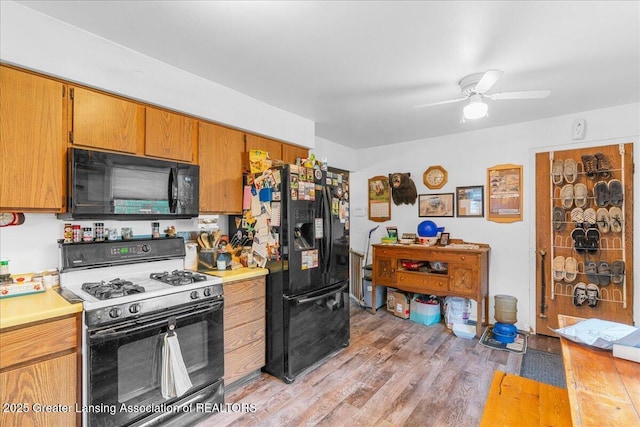 10111 Kinneville Rd, Eaton Rapids, MI 48827 - kitchen with black appliances, ceiling fan, light countertops, light wood finished floors, and brown cabinets