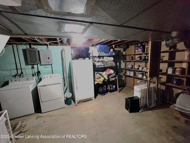 1048 Chris J Dr, Lansing, MI 48917 - unfinished basement with washing machine and dryer, electric panel, and freestanding refrigerator