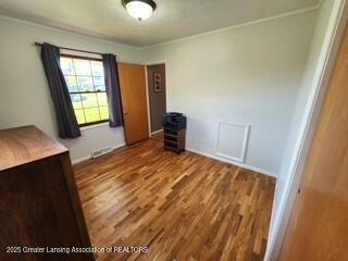 1048 Chris J Dr, Lansing, MI 48917 - unfurnished bedroom featuring wood finished floors and baseboards