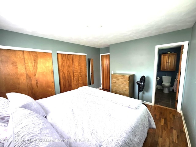 1048 Chris J Dr, Lansing, MI 48917 - bedroom featuring dark wood finished floors, baseboards, multiple closets, and ensuite bathroom