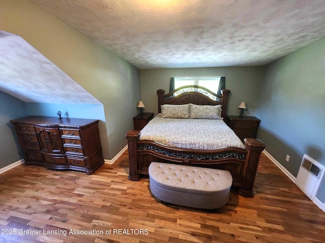 1048 Chris J Dr, Lansing, MI 48917 - bedroom featuring wood finished floors, baseboards, and a textured ceiling