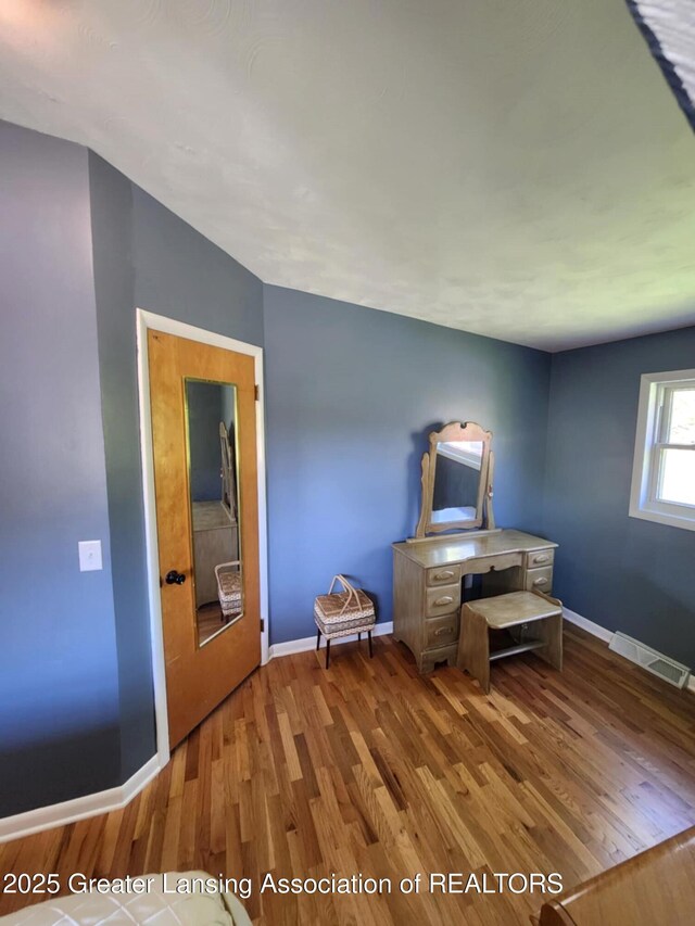 1048 Chris J Dr, Lansing, MI 48917 - unfurnished bedroom with wood finished floors and baseboards