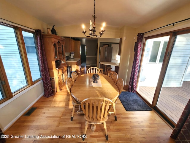 1048 Chris J Dr, Lansing, MI 48917 - dining space featuring light wood-style floors, a chandelier, and plenty of natural light
