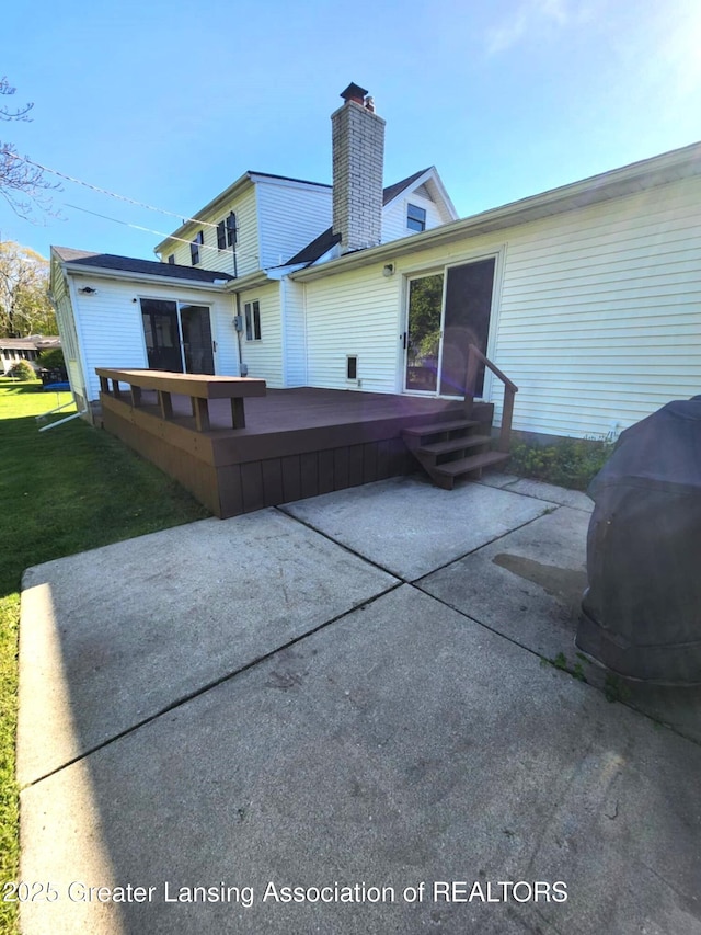 1048 Chris J Dr, Lansing, MI 48917 - rear view of property featuring a patio area, a chimney, a wooden deck, and a yard