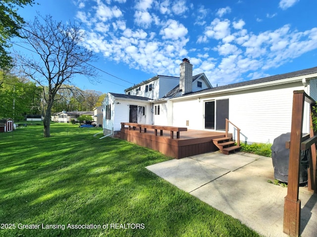 1048 Chris J Dr, Lansing, MI 48917 - back of house with a lawn, a wooden deck, a patio, and a chimney