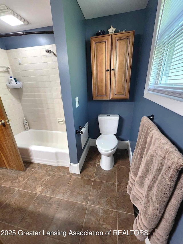1048 Chris J Dr, Lansing, MI 48917 - full bathroom with toilet, baseboards, shower / bathtub combination, and tile patterned flooring