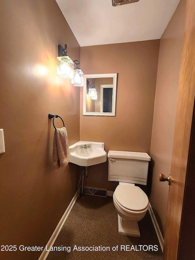 1048 Chris J Dr, Lansing, MI 48917 - bathroom with toilet, baseboards, and a sink