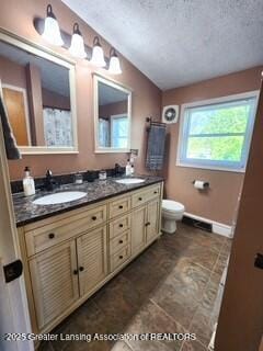 1048 Chris J Dr, Lansing, MI 48917 - full bath featuring toilet, double vanity, baseboards, and a textured ceiling