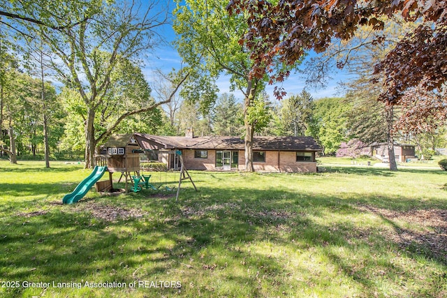 160 Lincoln Hill Dr, Battle Creek, MI 49015 - back of property with a playground, a chimney, a yard, and brick siding