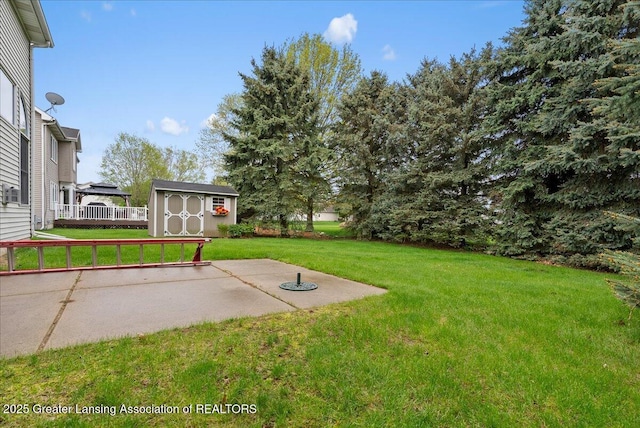 13503 Cottonwood Ct, Dewitt, MI 48820 - view of green lawn with an outdoor structure, a patio area, a storage unit, and a deck