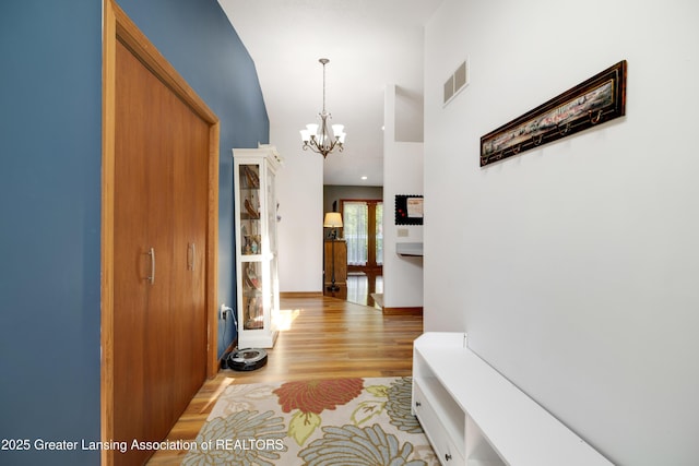 2335 N Concord Rd, Albion, MI 49224 - corridor featuring a chandelier, light wood-style floors, high vaulted ceiling, and baseboards