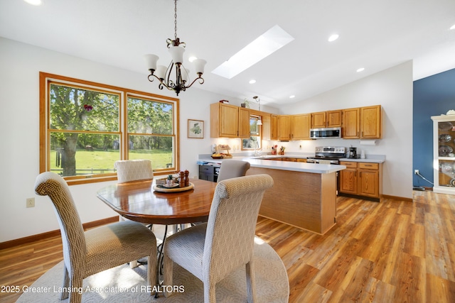 2335 N Concord Rd, Albion, MI 49224 - dining room with vaulted ceiling, a chandelier, light wood-style floors, a skylight, and baseboards