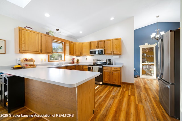 2335 N Concord Rd, Albion, MI 49224 - kitchen featuring stainless steel appliances, vaulted ceiling, a peninsula, light countertops, and pendant lighting