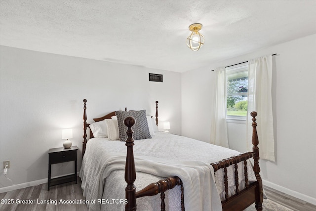 13321 Russell Rd, Lake Odessa, MI 48849 - bedroom with wood finished floors, baseboards, and a textured ceiling