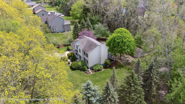 aerial view of property and surrounding area featuring a forest