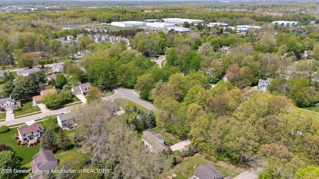 aerial view of property's location featuring a forest and nearby suburban area