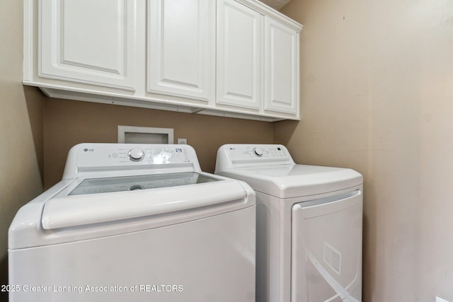 laundry room with cabinet space and washer and clothes dryer