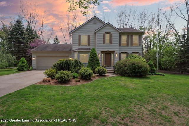 traditional-style home featuring a garage, concrete driveway, and a yard