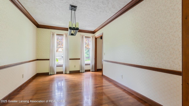 4245 Sandridge Dr, Okemos, MI 48864 - empty room featuring wood finished floors, crown molding, a textured ceiling, wallpapered walls, and baseboards