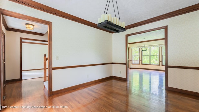 4245 Sandridge Dr, Okemos, MI 48864 - unfurnished room with crown molding, wood finished floors, baseboards, and a chandelier