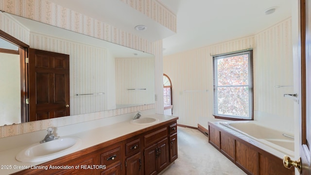 4245 Sandridge Dr, Okemos, MI 48864 - bathroom with wallpapered walls, double vanity, a bath, and baseboards
