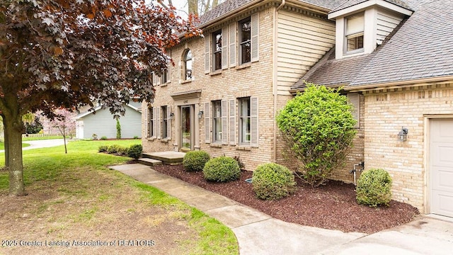 4245 Sandridge Dr, Okemos, MI 48864 - view of home's exterior with a yard, brick siding, and a shingled roof
