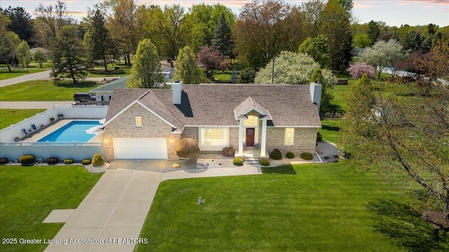 1801 Tahyio Rd, Owosso, MI 48867 - view of front of house with a chimney, stone siding, concrete driveway, and a shingled roof