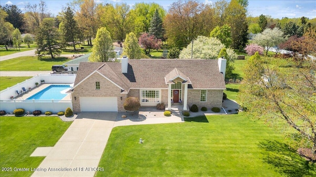 1801 Tahyio Rd, Owosso, MI 48867 - view of front facade with a chimney, driveway, stone siding, and a garage