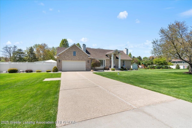 1801 Tahyio Rd, Owosso, MI 48867 - view of front of home featuring a garage, a chimney, concrete driveway, and brick siding