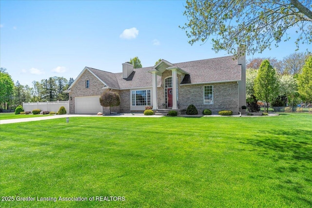 1801 Tahyio Rd, Owosso, MI 48867 - view of front of home with a chimney, stone siding, concrete driveway, a garage, and roof with shingles