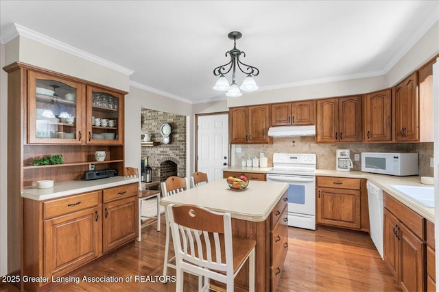 1801 Tahyio Rd, Owosso, MI 48867 - kitchen featuring white appliances, brown cabinets, a kitchen bar, light countertops, and ornamental molding
