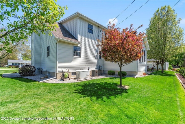 1801 Tahyio Rd, Owosso, MI 48867 - back of property featuring central air condition unit, a lawn, and roof with shingles