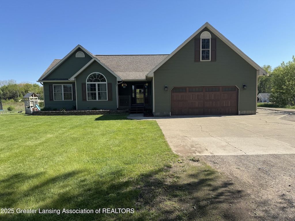 view of front facade with driveway, a front yard, and an attached garage