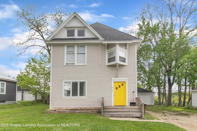 114 Haze St, Lansing, MI 48917 - view of front facade with a front lawn, a shingled roof, and a detached garage