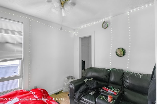 114 Haze St, Lansing, MI 48917 - living area with wood finished floors, baseboards, and ceiling fan