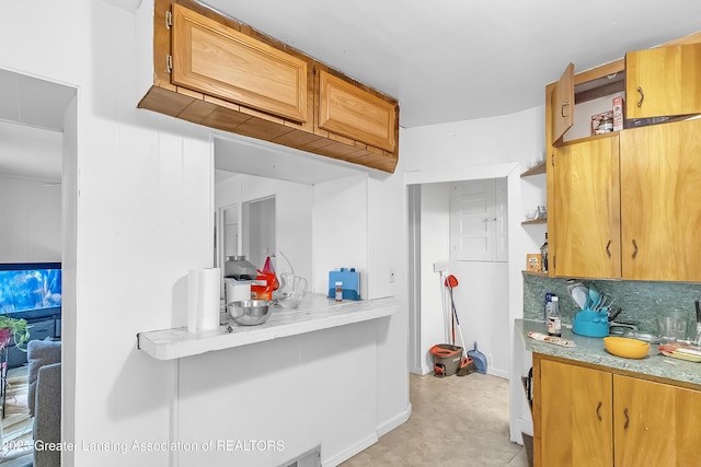 114 Haze St, Lansing, MI 48917 - kitchen featuring open shelves, light countertops, tasteful backsplash, and baseboards