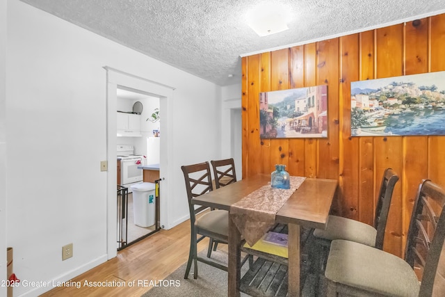 922 Dakin St, Lansing, MI 48912 - dining area featuring light wood finished floors, a textured ceiling, and baseboards