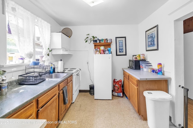 922 Dakin St, Lansing, MI 48912 - kitchen featuring a sink, white electric range oven, light flooring, brown cabinets, and under cabinet range hood